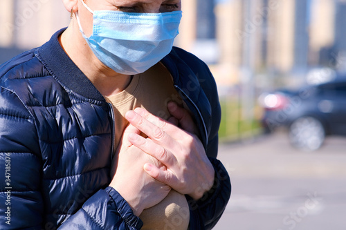 Foto A masked woman in the street felt a twinge of pain in her chest