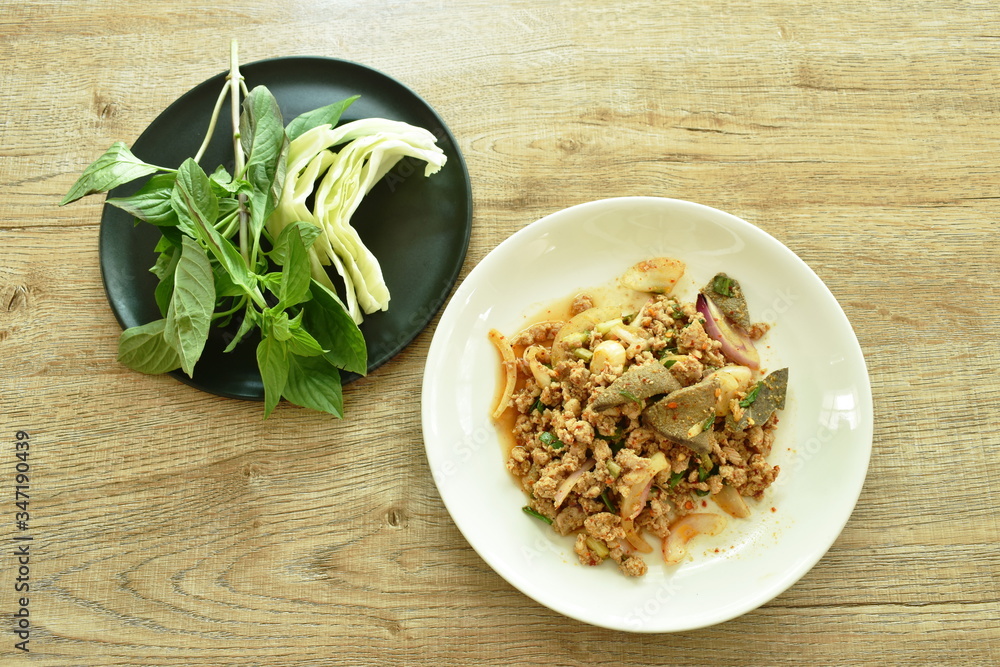 Thai spicy minced pork salad and fresh vegetable on plate