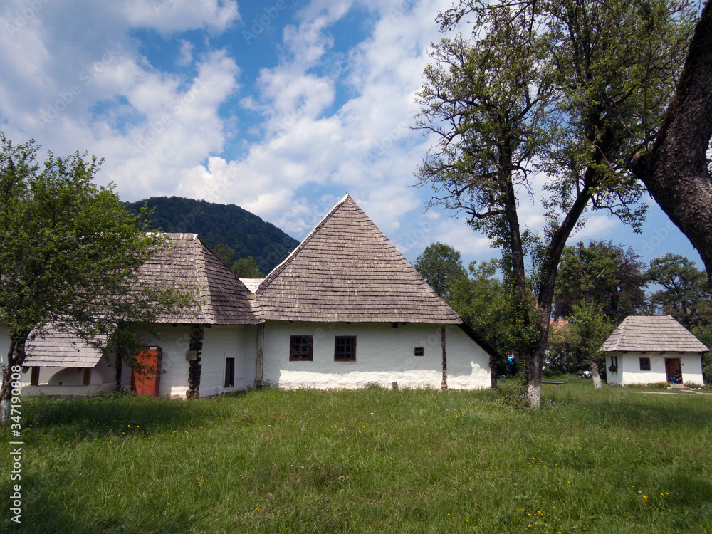 Group of old white-washed shingled cottages, Bran, Romania