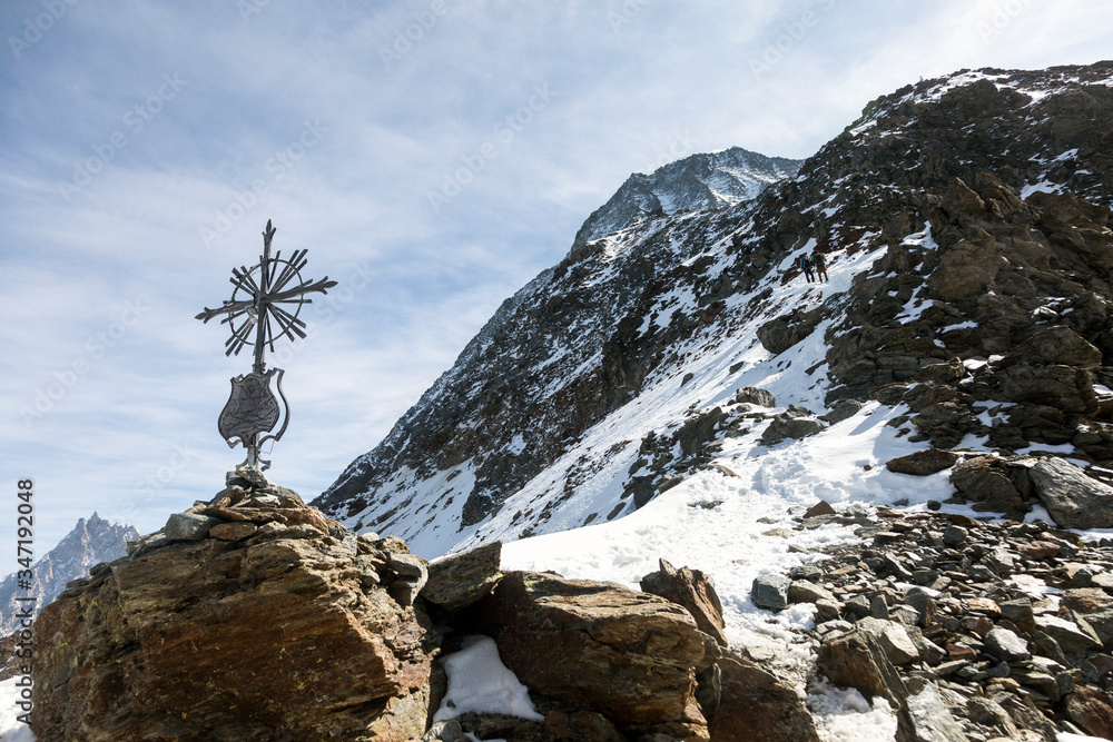 Fototapeta premium Haute-Savoie cross and stones near the Grand Couloir of Mont-blanc massif in the French Alps, Chamonix-Mont-Blanc, France. Scenic image of hiking concept