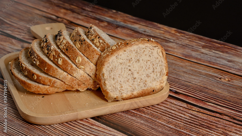 Slice whole grain bread on the wooden table. Slice whole grain bread on the wooden table.