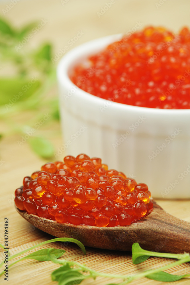 A small ceramic bowl with red caviar
