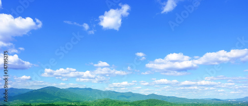 The blue sky has beautiful green mountains. 