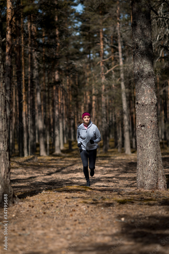 running in the woods. Girl is engaged in sports in the pine forest. running in the woods. Girl is engaged in sports in the pine forest.
