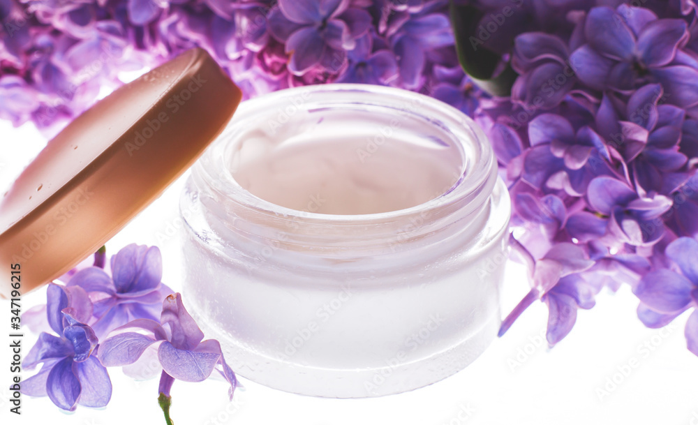 Wet jar with body cream and flowers Wet jar with body cream and flowers