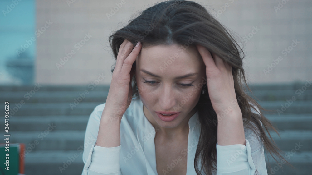 Crisis 2020 banner. People lost their work. Unhappy brunette young business woman feel worried about job loss sitting on stairway. Pandemic. Quarantine. Crisis 2020 banner. People lost their work. Unhappy brunette young business woman feel worried about job loss sitting on stairway. Pandemic. Quarantine.