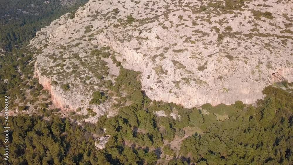 Sideways aerial shot of rocky cliffs inside a forest. 4K video quality Sideways aerial shot of rocky cliffs inside a forest. 4K video quality