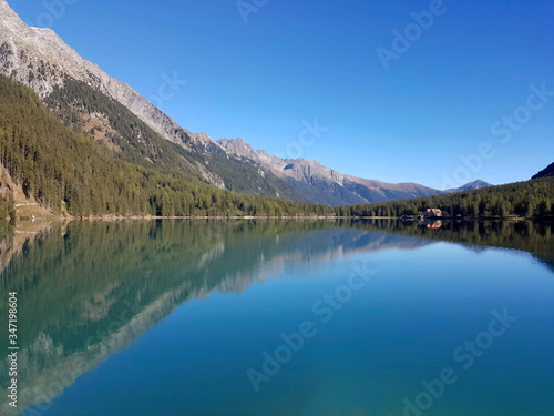 mountain lake with pure blue waters and agricultural hut in the background