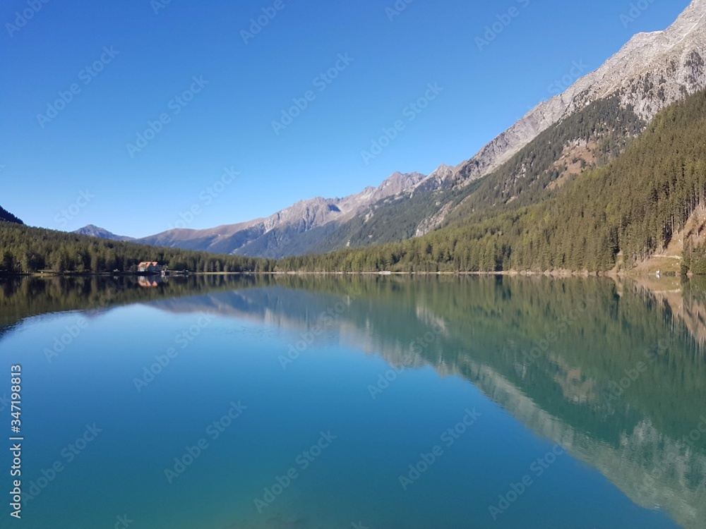 mountain lake with pure blue waters and agricultural hut in the background