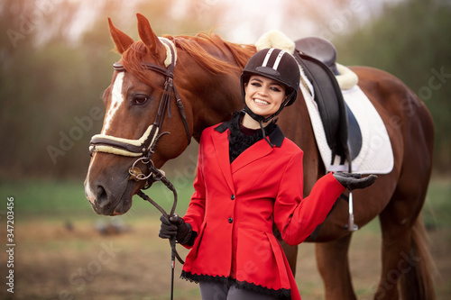 Fashion photo Equestrian sport Woman jockey with brown horse, outdoors