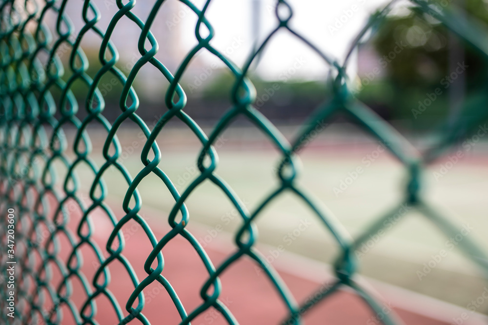 Naklejka premium Close-up chain link fence , Sunset background