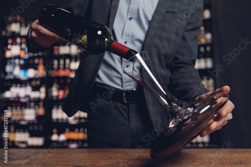 Foto Sommelier pouring red wine into carafe decanter to make aeration drink