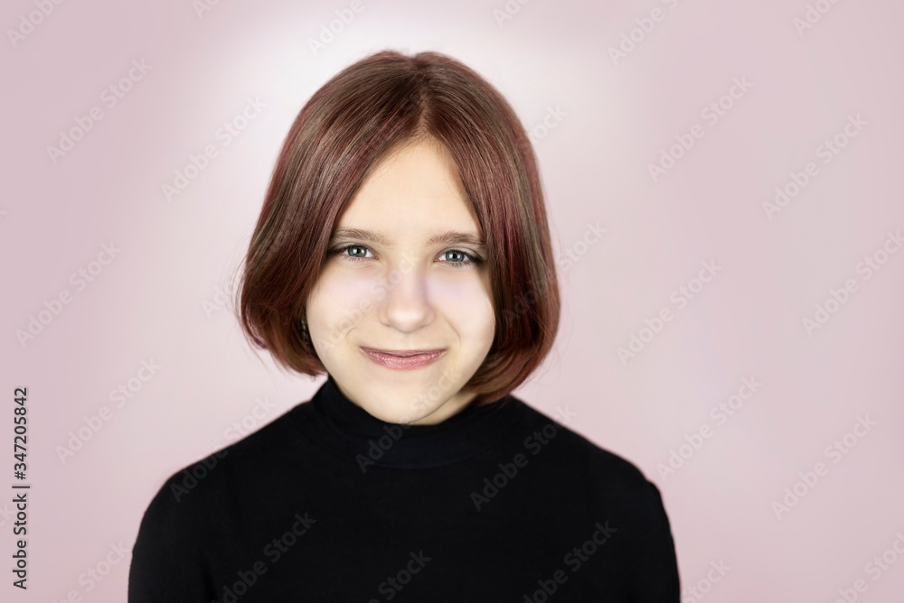 Obraz premium Portrait of a cute beautiful teenage girl on a pink background, the girl has painted hair and a new hairstyle. Girl smiling