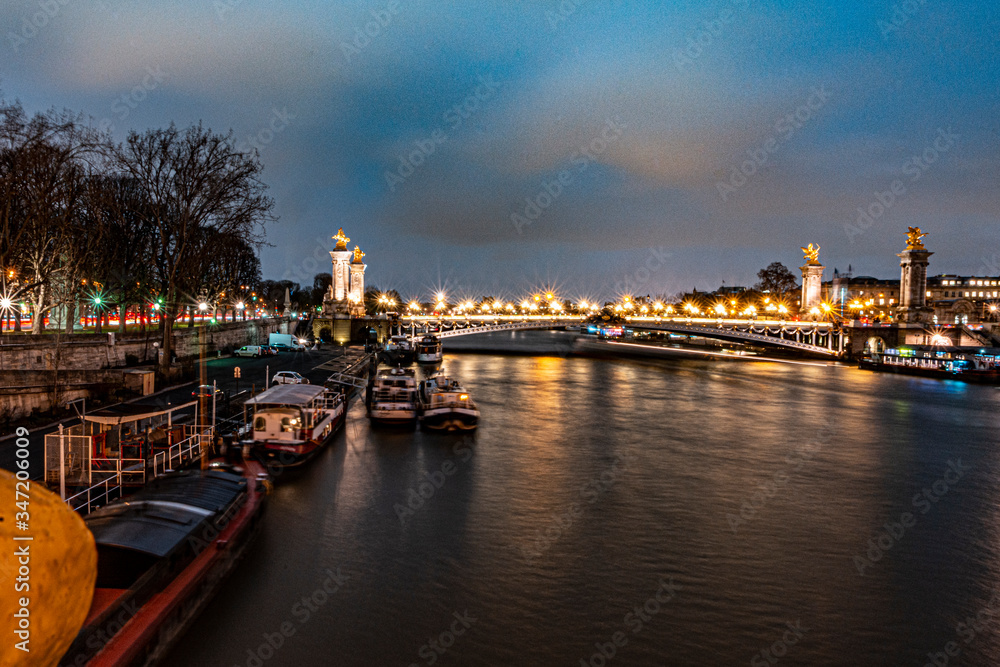Naklejka premium beautiful urban landscape of the seine river bordered the city of paris, in the river you can see some boats that make a house, a bridge in the distance and a sky with blue color and clouds