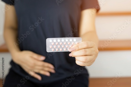 Women holding birth control pills in their hands