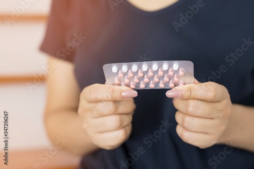 Women holding birth control pills in their hands