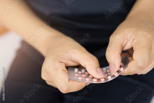 Close-up Showing pictures of women holding birth control pills in their hands