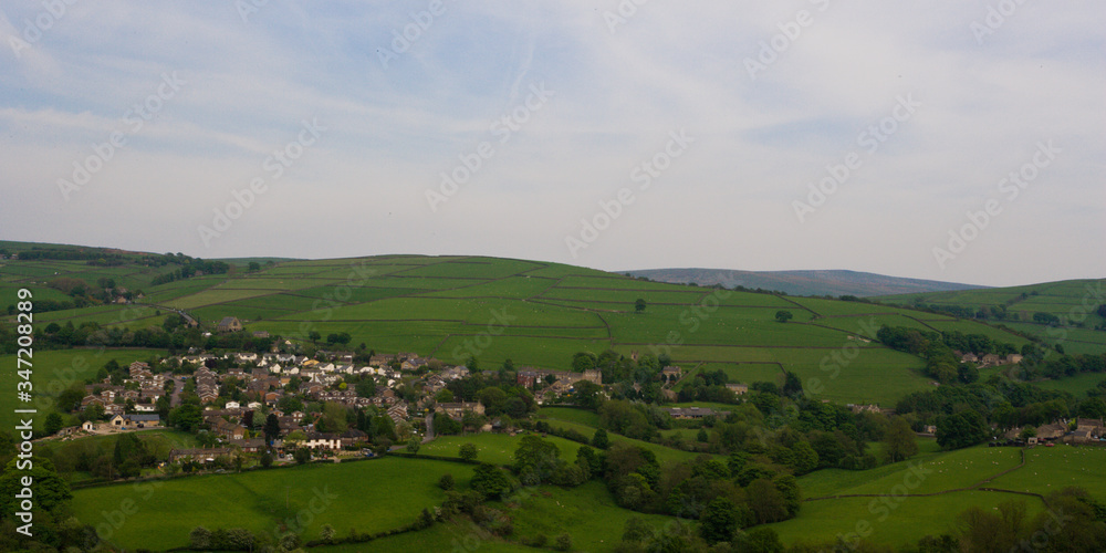 View of small rural British village and surrounding hills from a distance
