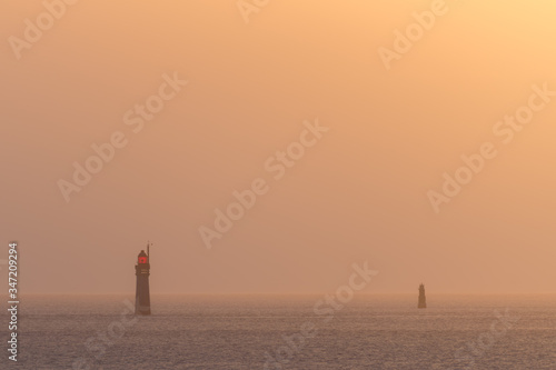 Lighthouses during sunset over a calm sea