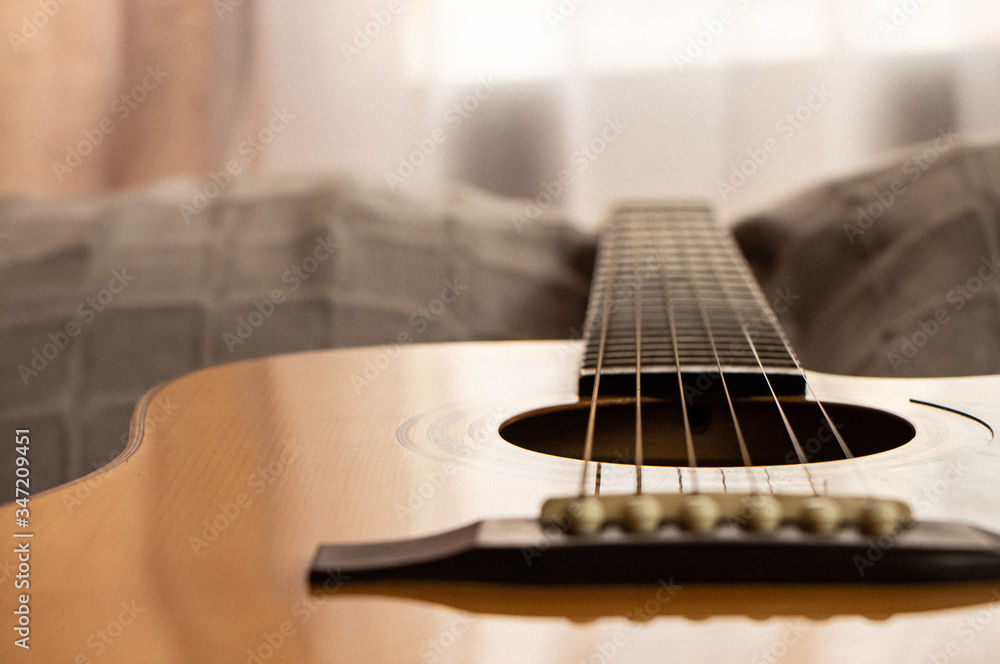 Guitar close-up view. Overexposed background. Selective focus. Copy space. Grain. Guitar close-up view. Overexposed background. Selective focus. Copy space. Grain.