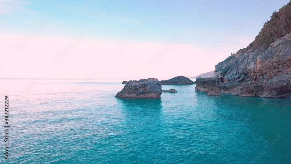 Aerial orbiting reveal drone shot around a big rock in the crystal clear waters of the Aegean sea in Greece Aerial orbiting reveal drone shot around a big rock in the crystal clear waters of the Aegean sea in Greece