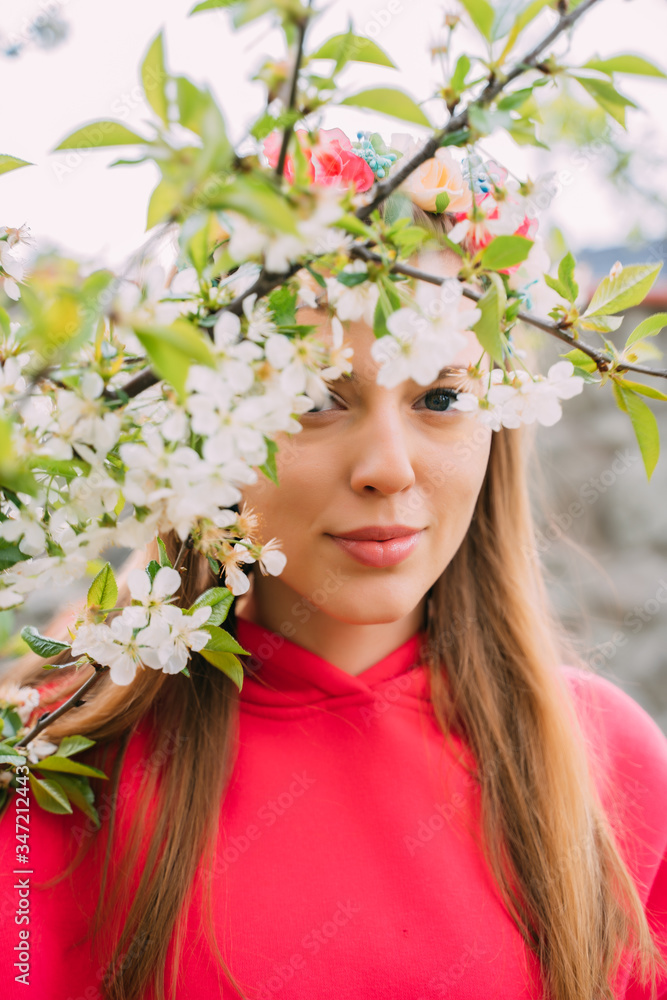 Obraz premium Girly in pink hoody stands in white flowers