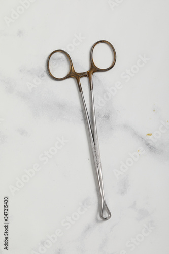 surgical metal plier on marble back medical tool © robin-clouet.fr