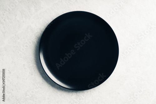 Clean black plate on the rustic background. Selective focus. Shot from above.