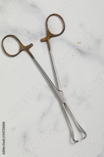 surgical metal plier on marble back medical tool © robin-clouet.fr