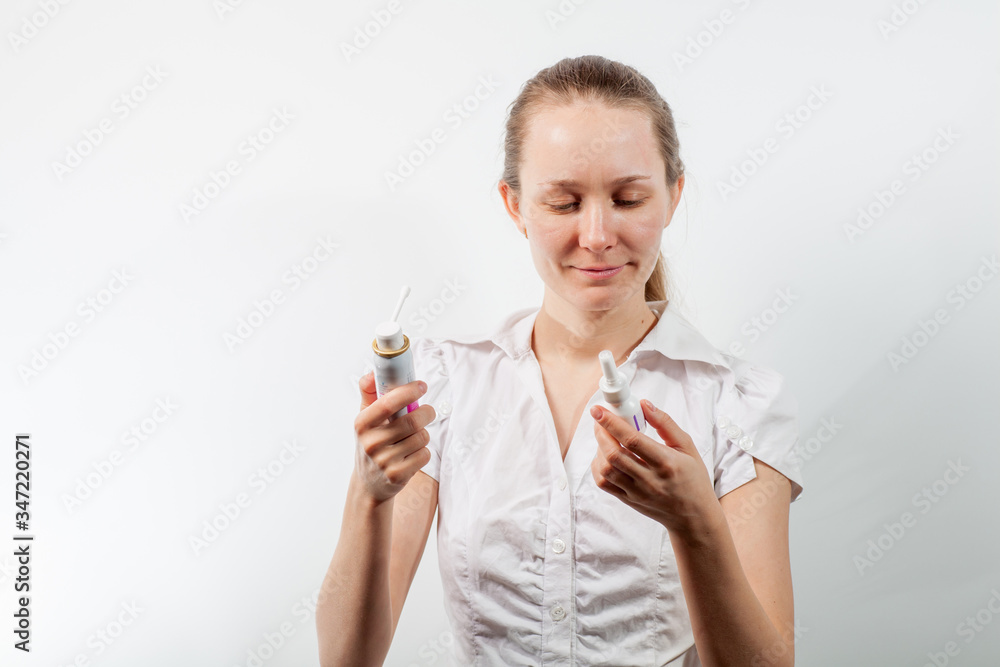 Young and attractive doctor with a throat spray isolated on white Young and attractive doctor with a throat spray isolated on white