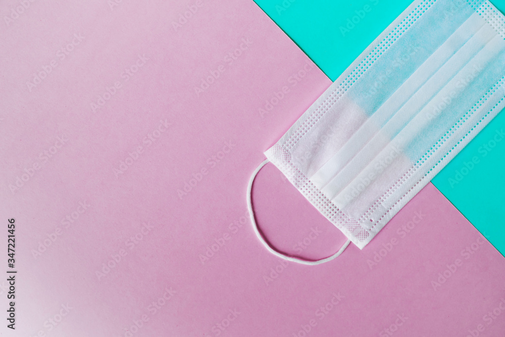 Medical mask on a pastel pink and blue geometry background. Prevent the coronavirus. Protection concept Medical mask on a pastel pink and blue geometry background. Prevent the coronavirus. Protection concept