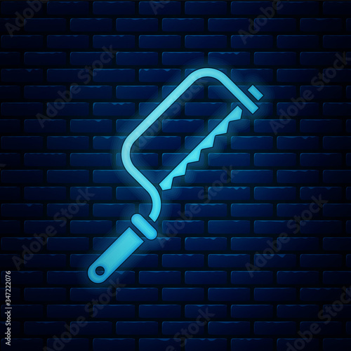 Glowing neon Hacksaw icon isolated on brick wall background. Metal saw for wood and metal.  Vector Illustration