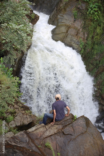 Man enjoying the view of the waterfall in Khlong Wang Chao Kamphaeng Phet National Park, Thailand