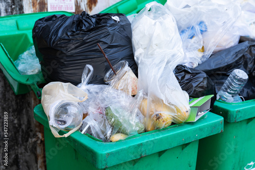 Overflowing garbage bins with household waste