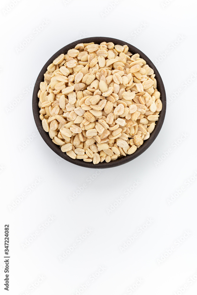 Salty Peanuts in round bowl on white background, top view