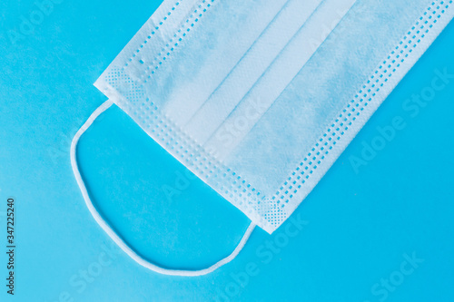 Medical mask on a pastel teal blue background. Prevent the coronavirus covid 19. Protection concept