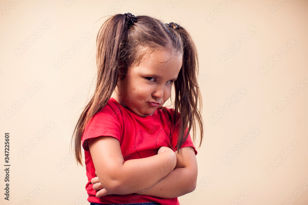 A portrait of kid girl showing sad expression. Childhood and emotions concept