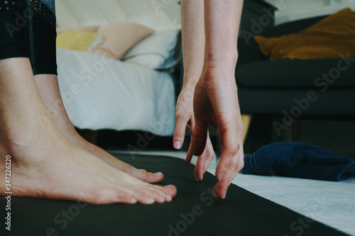 Woman bent over stretching after home workout in her room