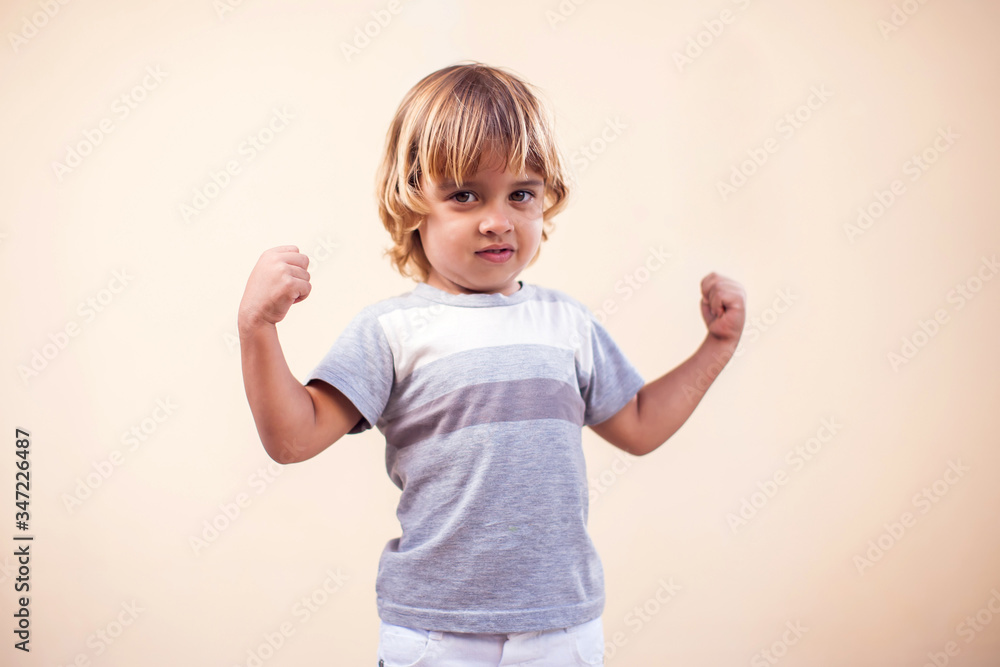 A portrait of kid boy showing strong hands. Childhood and health concept A portrait of kid boy showing strong hands. Childhood and health concept