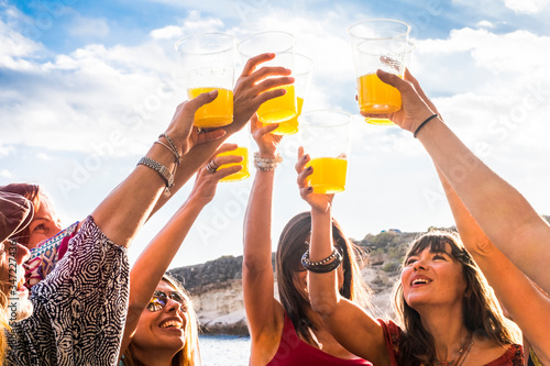 Group of happy and cheerful young women friends enjoy and celebrate social life together - people toasting and clinking outdoor enjoying friendship and contact