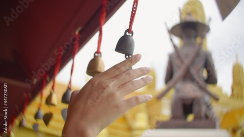 Hand close up of female hand with bell to travel , Ancient city thailand 

