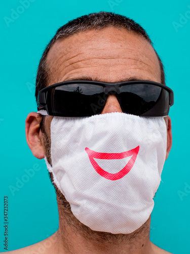 optimistischer Mann mit Maske gegen Corona und Sonnenbrille