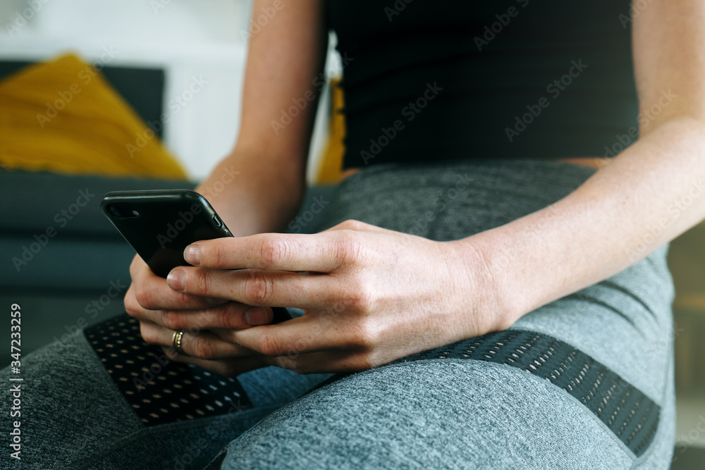 Phone online fitness class fit woman using mobile app at home Phone online fitness class fit woman using mobile app at home