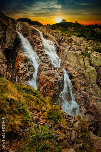 Sunset over a waterfall in the mountains.