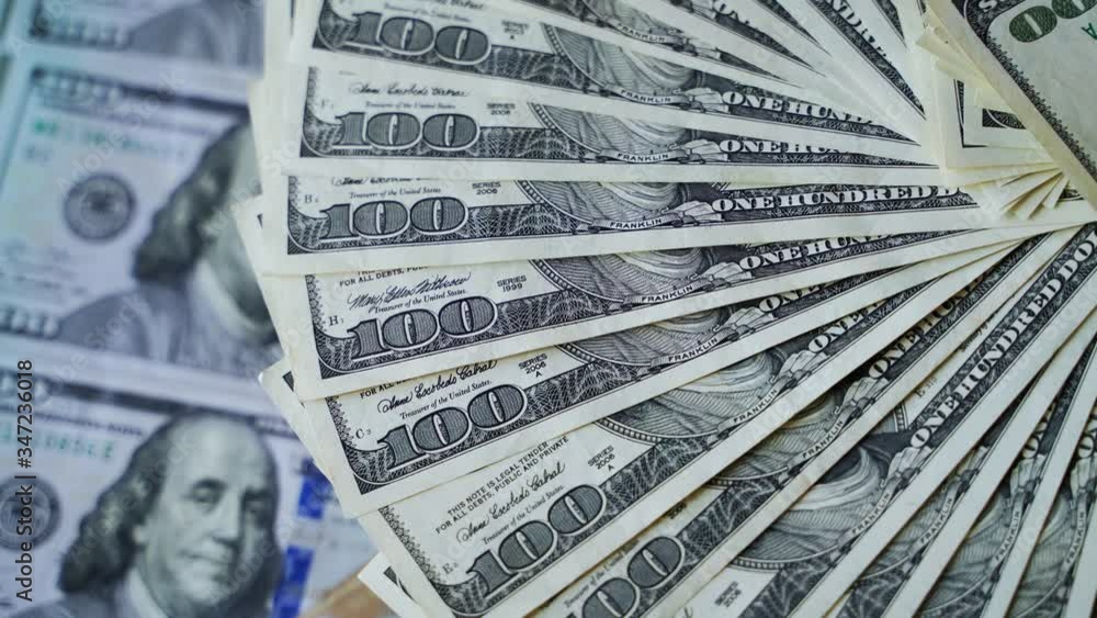 Dollar banknotes decomposed in a circle. Rotation of one hundred dollar bills. Background of american money. Close-up. Dollar banknotes decomposed in a circle. Rotation of one hundred dollar bills. Background of american money. Close-up.