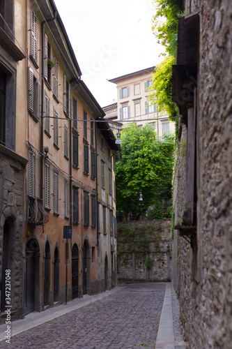 Traditional narrow Italian street and no people in Bergamo historical center  Italy. Medieval buildings. There s no one on the street.