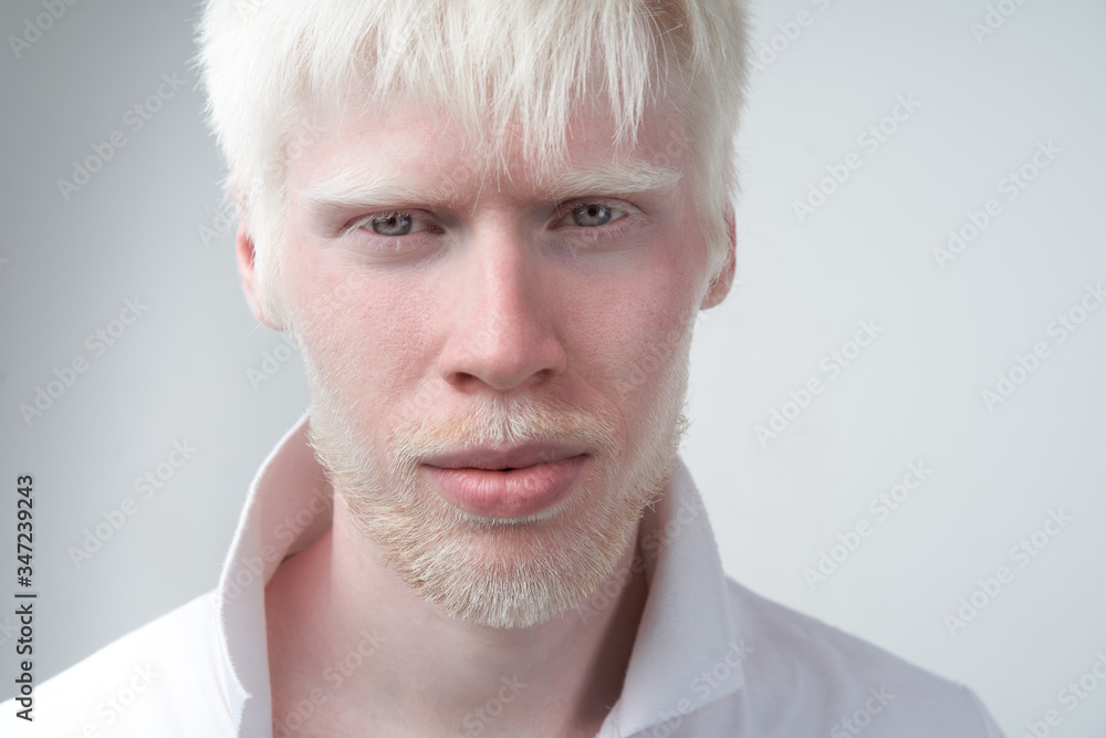 portrait of an albino man in studio dressed t-shirt isolated on a white background. abnormal deviations. unusual appearance - obrazy, fototapety, plakaty 