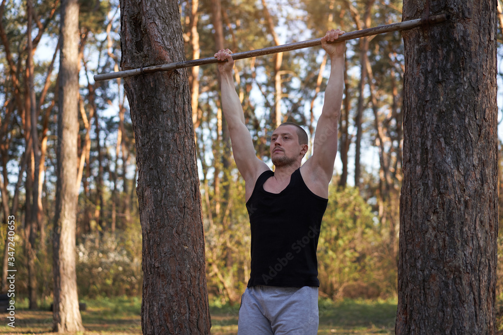 Handsome caucasian men pull-up outdoor workout cross training morning Pumping up arm exercising sports ground nature forest Handsome caucasian men pull-up outdoor workout cross training morning Pumping up arm exercising sports ground nature forest