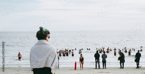 Woman watching how people bathe in the sea