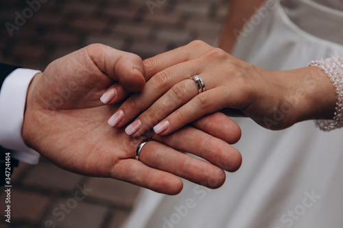 Hands of the bride and groom. Bride and groom holding hands at a wedding ceremony. Wedding rings on the hands of the newlyweds.